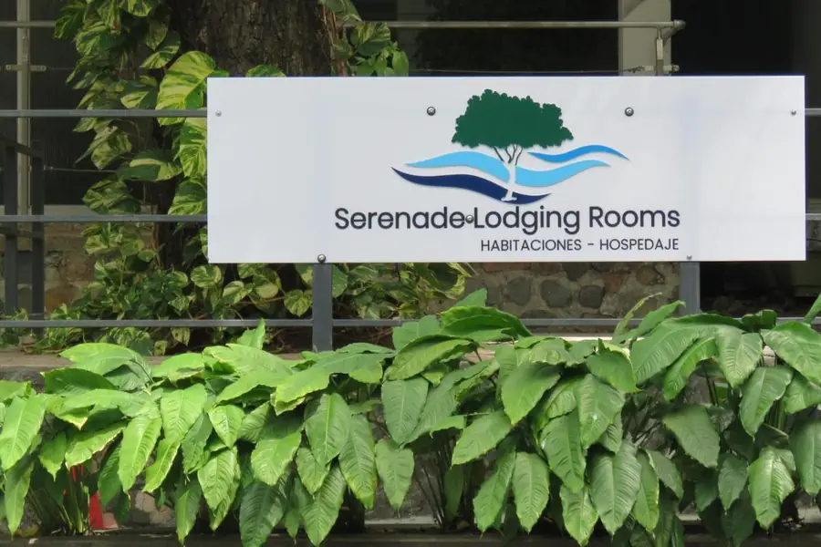 La entrada de Serenade Lodging Rooms con su cartel, entre plantas, en el barrio de San Francisco, Ciudad de Panamá
